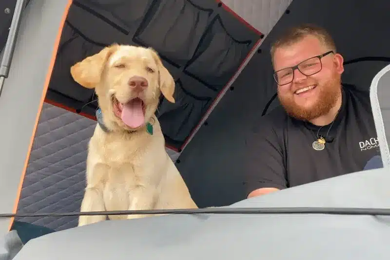 aussergewoehnliche unterkunt mit hund dachzelt mann
